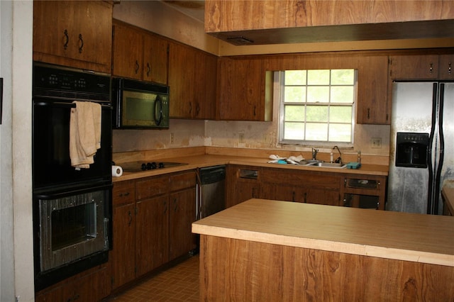 kitchen featuring sink, dark tile patterned floors, and black appliances