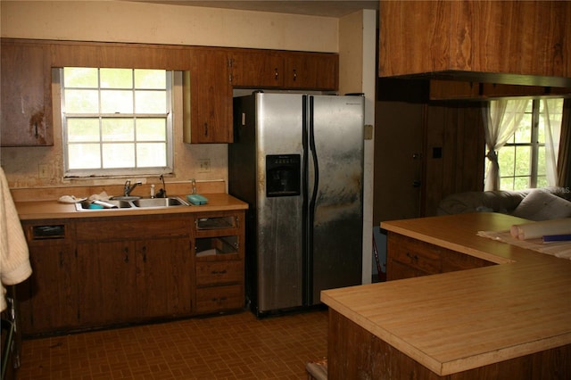 kitchen featuring sink, dark tile patterned flooring, and stainless steel fridge with ice dispenser