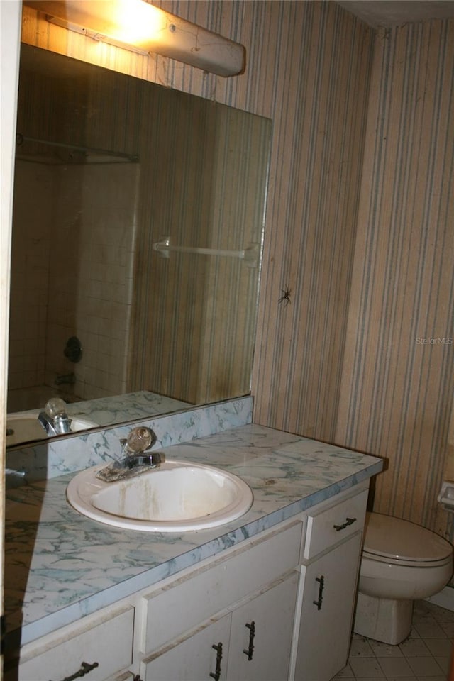 full bathroom featuring tiled shower / bath combo, vanity, tile patterned floors, and toilet