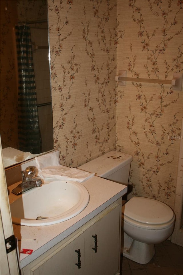 bathroom featuring vanity, tile patterned floors, and toilet