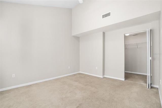 unfurnished bedroom with light colored carpet, ceiling fan, and a closet