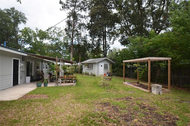 view of yard featuring a patio and an outbuilding