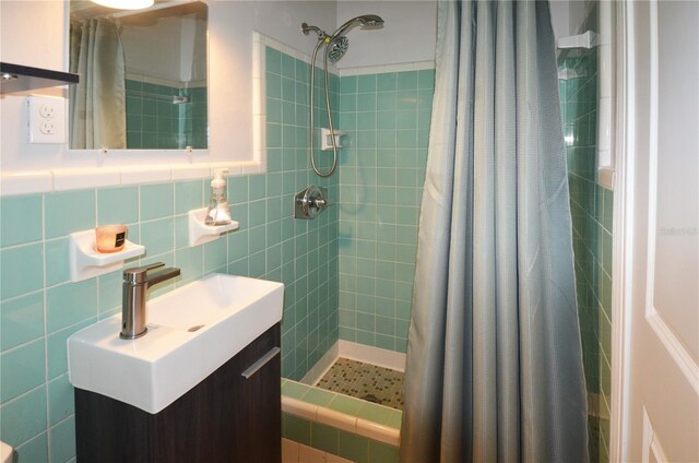 bathroom with walk in shower, tile walls, backsplash, and vanity