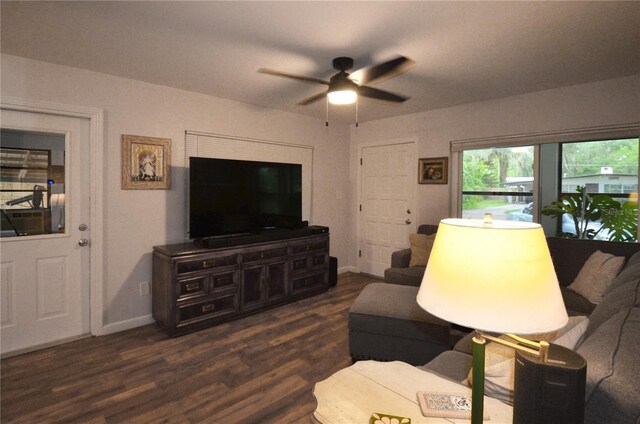 living room with ceiling fan and dark wood-type flooring