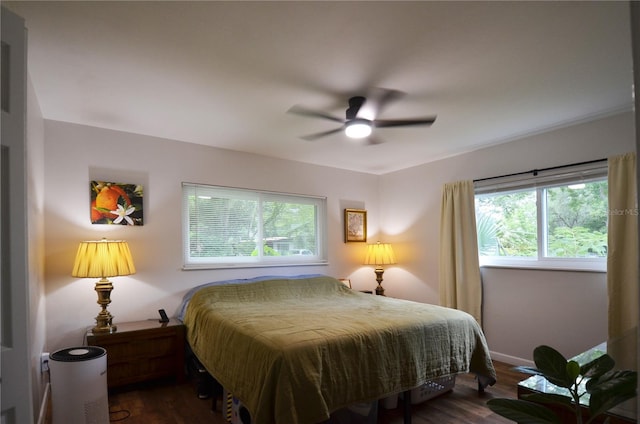 bedroom with dark hardwood / wood-style flooring and ceiling fan