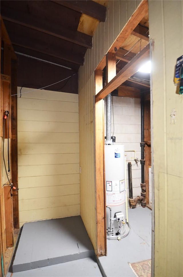 interior space with wood walls and water heater