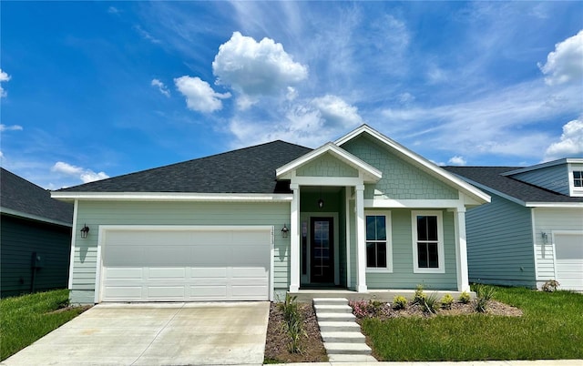 view of front of property with a garage, a shingled roof, and concrete driveway