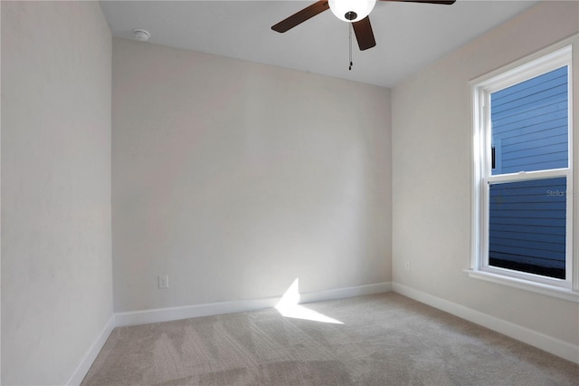 carpeted spare room with baseboards and a ceiling fan