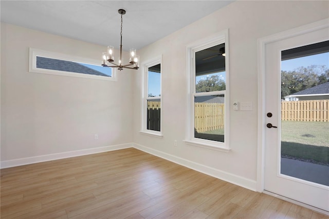 interior space with baseboards, an inviting chandelier, and light wood-style floors