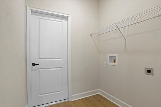 laundry room featuring light wood finished floors, hookup for a washing machine, electric dryer hookup, laundry area, and baseboards