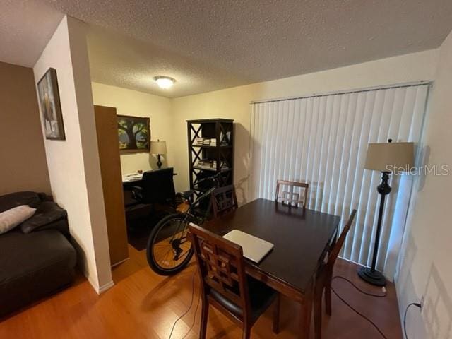 dining room with a textured ceiling and wood-type flooring