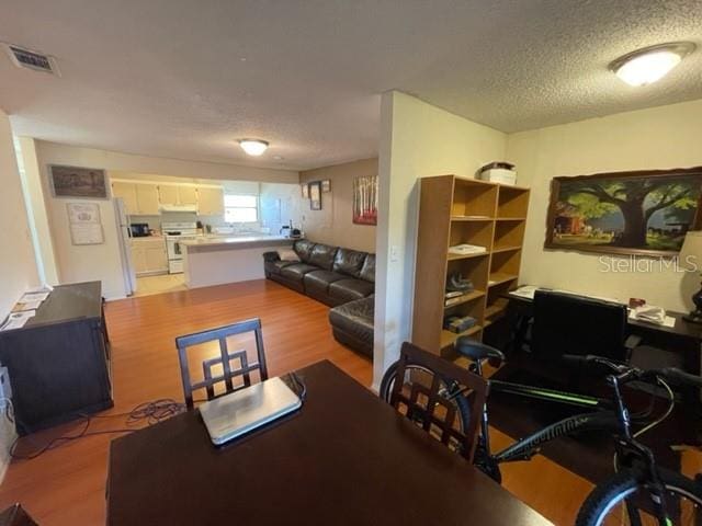 dining room with a textured ceiling and hardwood / wood-style flooring