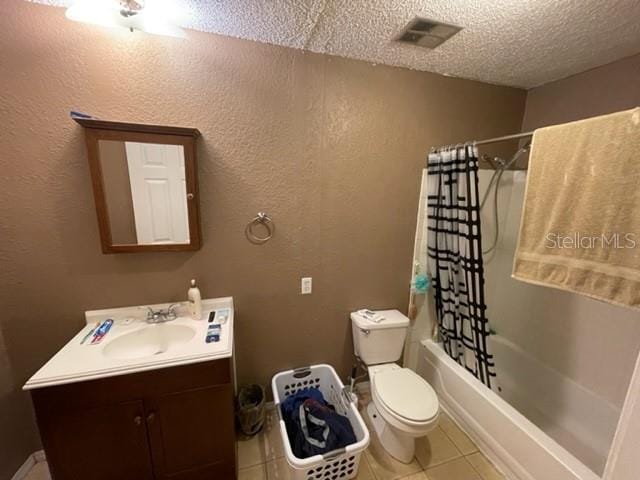 full bathroom featuring a textured ceiling, toilet, vanity, tile patterned floors, and shower / bath combo