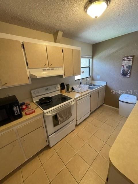 kitchen featuring sink, a textured ceiling, white appliances, and light tile patterned floors