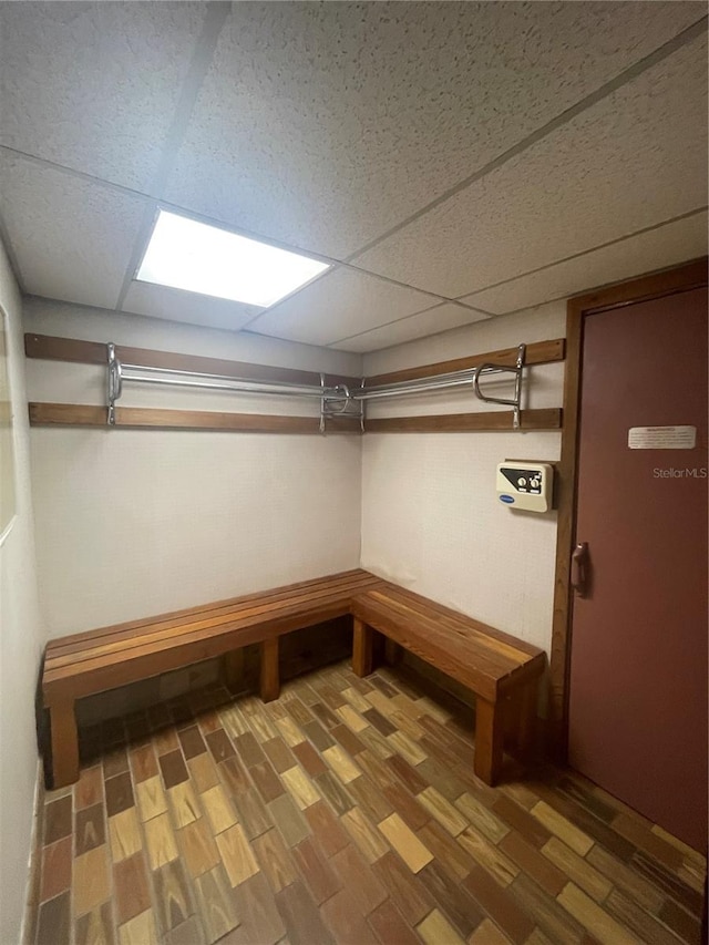 basement with hardwood / wood-style floors and a drop ceiling