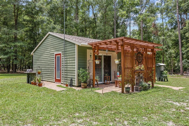 view of outbuilding with a pergola and a lawn