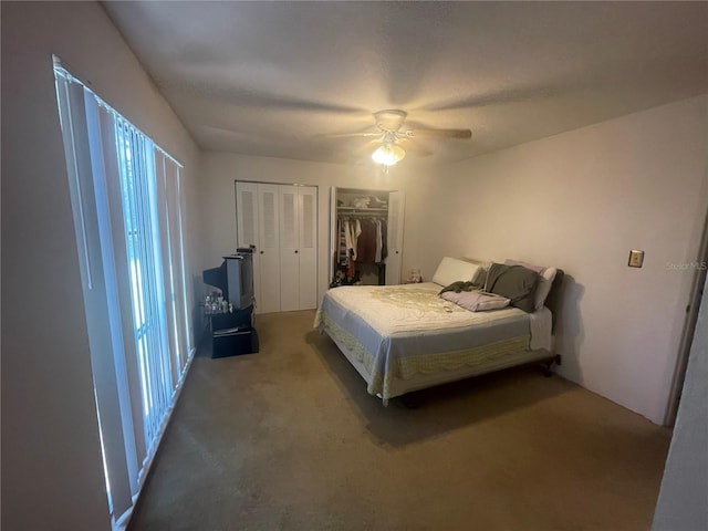 bedroom featuring ceiling fan, multiple closets, and carpet