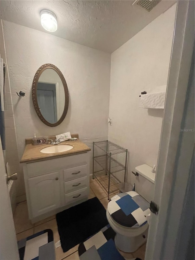 bathroom with toilet, a textured ceiling, and vanity