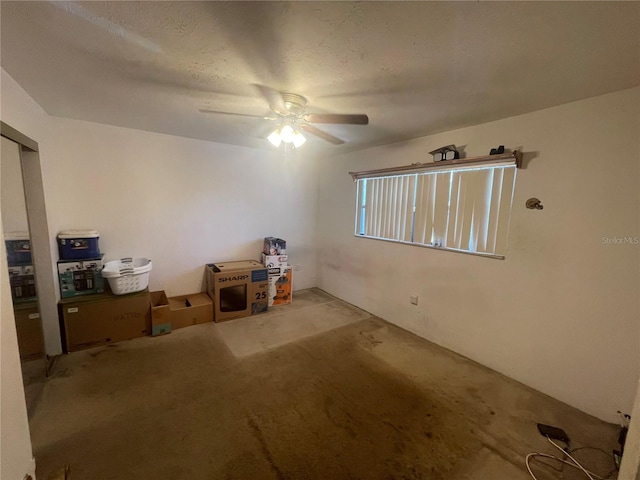 carpeted empty room with ceiling fan and a textured ceiling