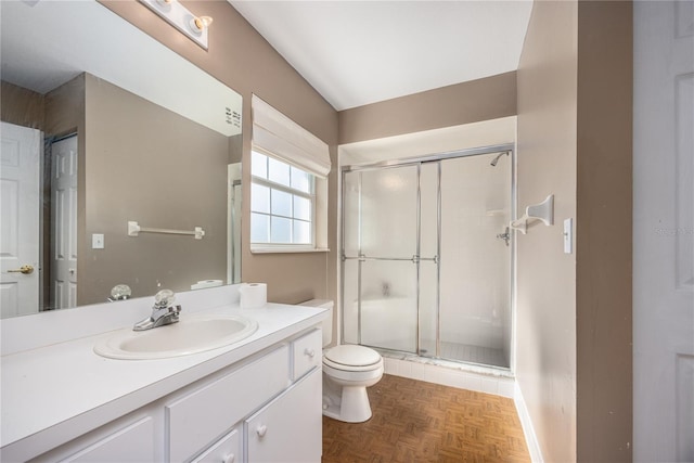 bathroom featuring parquet floors, vanity, walk in shower, and toilet