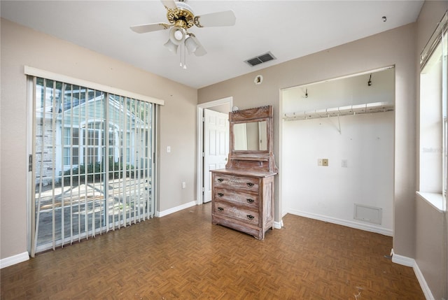 unfurnished bedroom featuring ceiling fan, multiple windows, a closet, and dark parquet floors