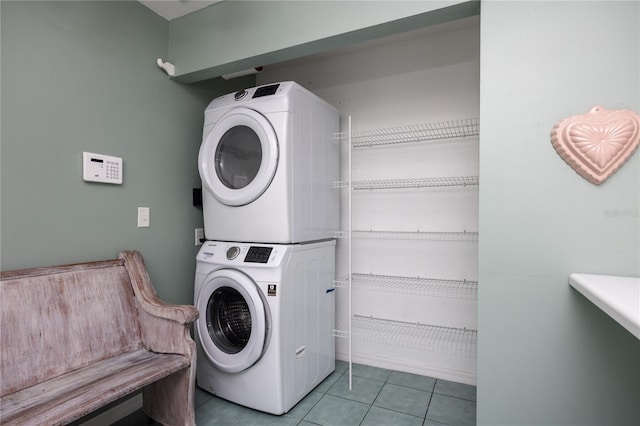 clothes washing area featuring stacked washing maching and dryer and light tile patterned floors