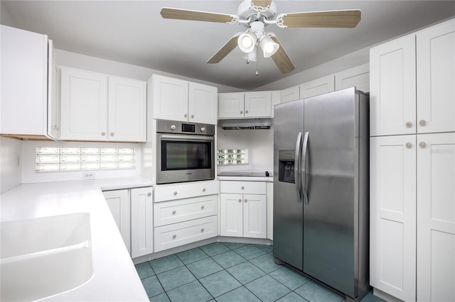 kitchen featuring appliances with stainless steel finishes, sink, light tile patterned flooring, white cabinetry, and ceiling fan