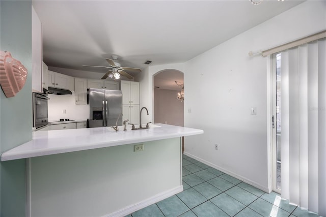 kitchen featuring light tile patterned flooring, white cabinetry, wall oven, and stainless steel refrigerator with ice dispenser