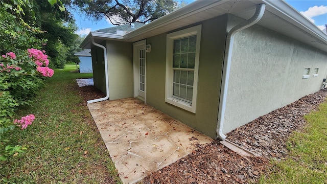 view of side of home featuring a patio and a yard