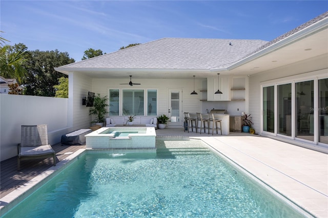 view of swimming pool featuring an in ground hot tub, an outdoor bar, a patio area, and ceiling fan