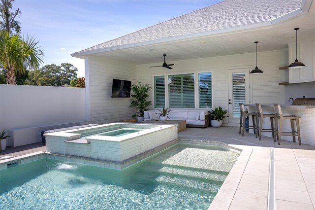 view of swimming pool featuring an in ground hot tub, exterior bar, a patio area, and ceiling fan