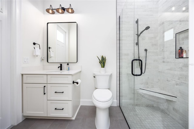 bathroom with a shower with shower door, tile patterned floors, toilet, and vanity