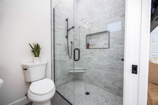 bathroom with an enclosed shower, tile patterned flooring, and toilet