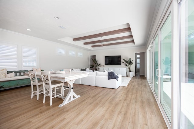 dining area with light hardwood / wood-style flooring and a raised ceiling