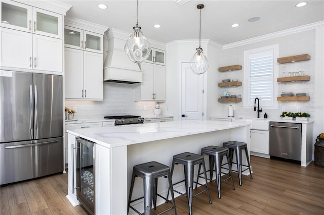 kitchen with appliances with stainless steel finishes, white cabinetry, custom exhaust hood, and dark wood-type flooring