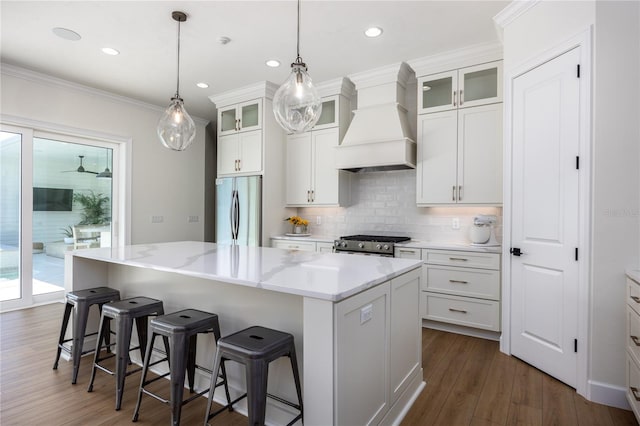 kitchen with a center island, dark wood-type flooring, stainless steel appliances, and custom range hood