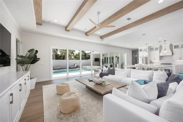 living room featuring hardwood / wood-style flooring, ornamental molding, beam ceiling, and ceiling fan