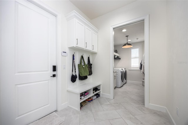 mudroom featuring separate washer and dryer and light tile patterned floors