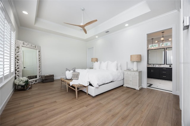 tiled bedroom with ceiling fan with notable chandelier, connected bathroom, crown molding, and a tray ceiling