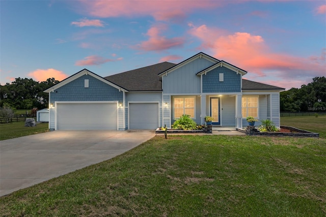 view of front of home featuring covered porch, a garage, and a yard