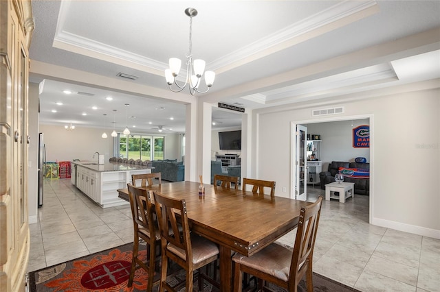 dining room featuring ornamental molding, sink, a chandelier, and a tray ceiling