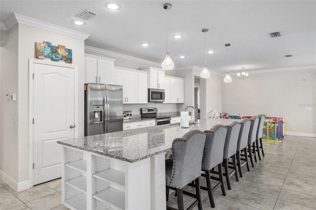 kitchen featuring light tile patterned floors, white cabinets, an island with sink, stainless steel appliances, and hanging light fixtures