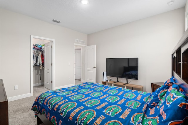 carpeted bedroom with a closet and a spacious closet