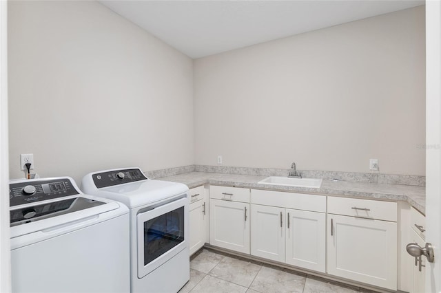 laundry room with cabinets, sink, light tile patterned flooring, and washer and dryer