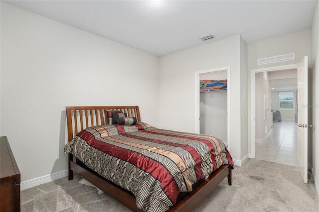 carpeted bedroom with a closet and a spacious closet