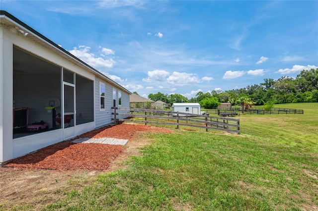 view of yard with a rural view and an outdoor structure