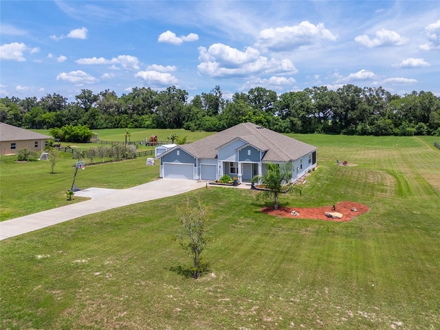 view of front of property with a rural view, a garage, and a front lawn