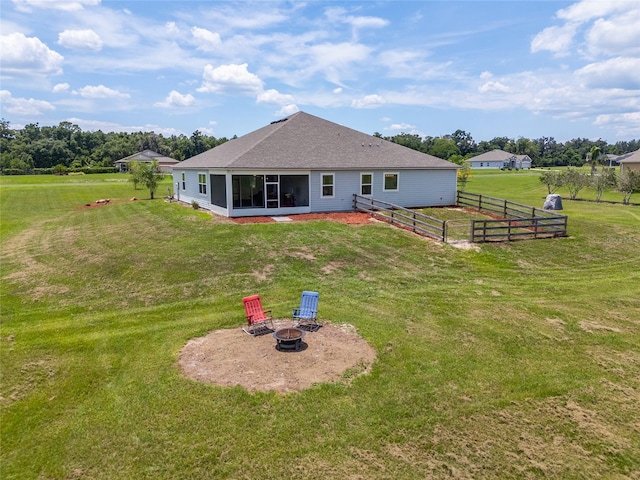 back of property featuring a yard and an outdoor fire pit