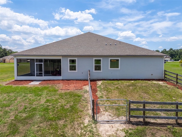 back of property featuring a sunroom and a yard