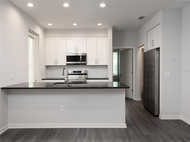 kitchen featuring appliances with stainless steel finishes, dark wood-type flooring, and white cabinetry